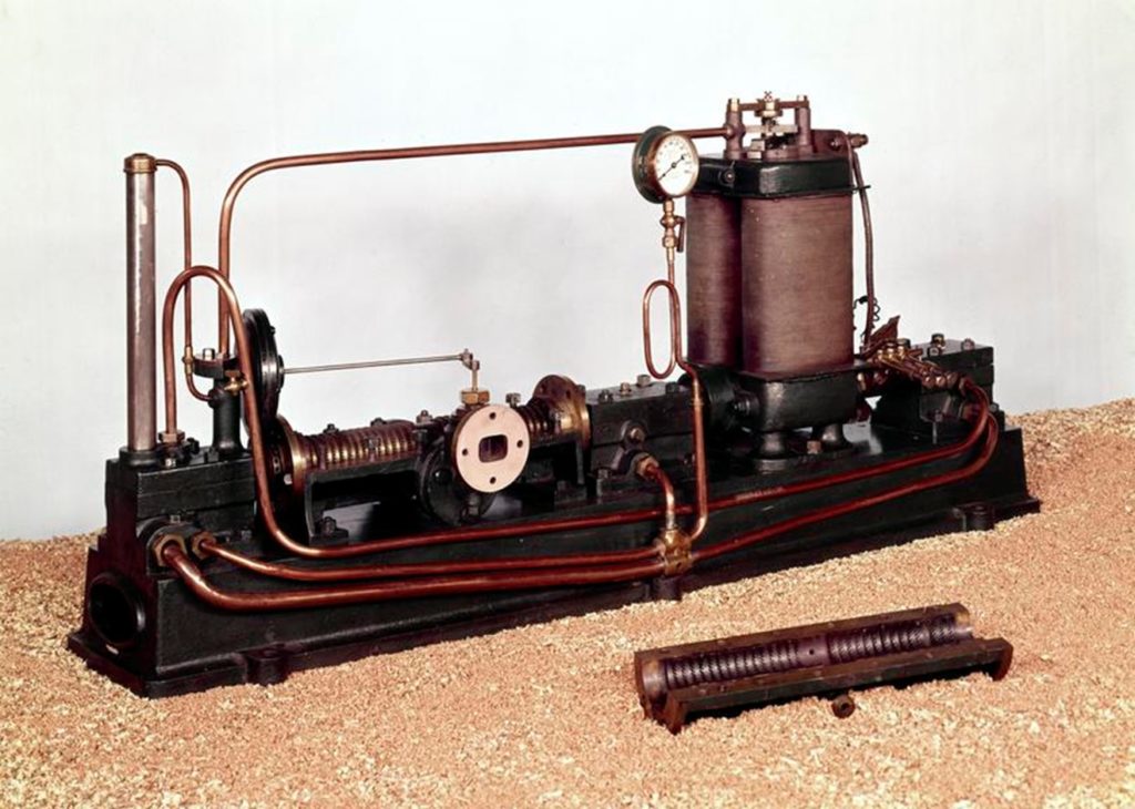 A photograph of a Parsons' original Steam Turbine generator with spare guide ring and fan.